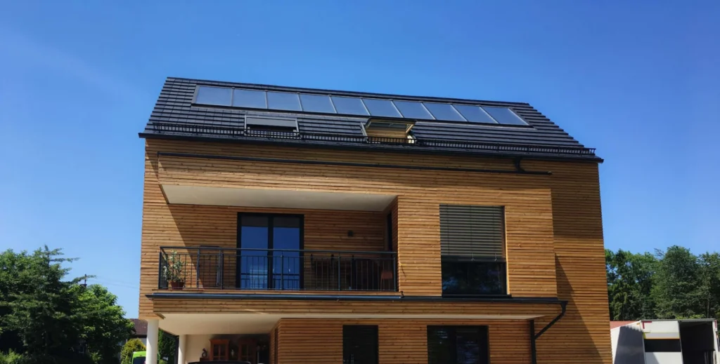 Modernes Holzhaus mit Holzfassade und großen Fenstern, gebaut von Zimmerei Brunner – Kombination aus traditionellem Handwerk und moderner Architektur